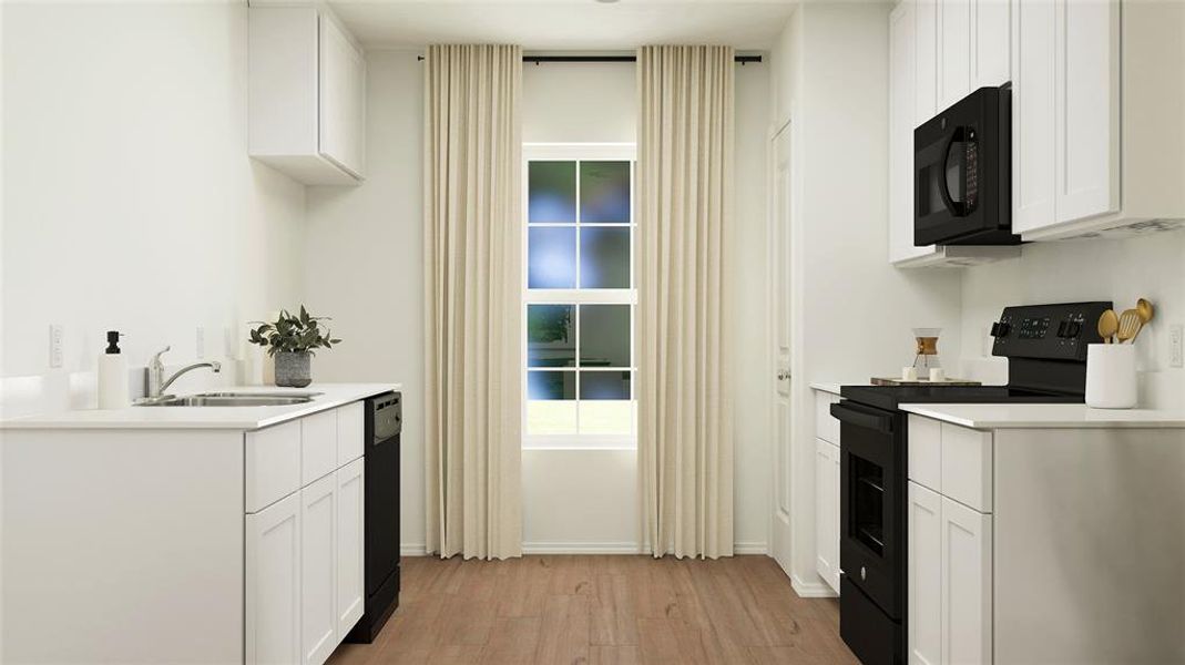 Kitchen with sink, light wood-type flooring, black appliances, and white cabinetry