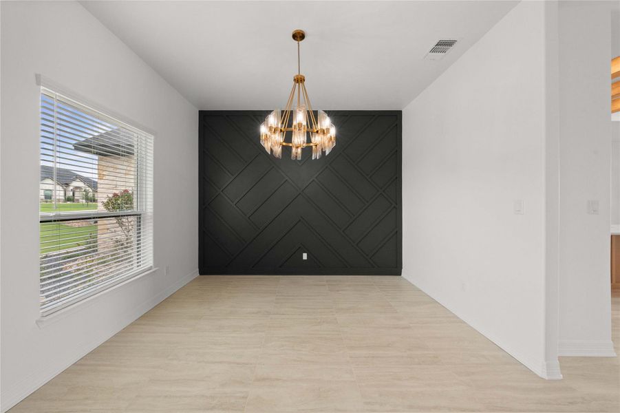 A striking accent wall with geometric molding anchors this versatile dining space. A striking accent wall with geometric molding anchors this versatile dining space.