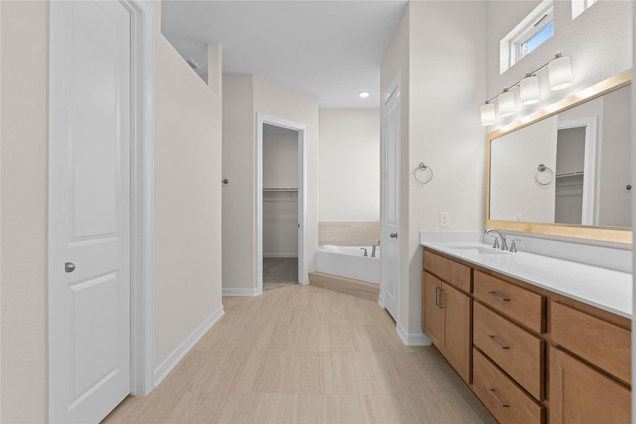 The primary bathroom entry leads into a spa inspired space featuring dual vanities, ample storage, and quality finishes, offering both convenience and luxury for daily routines.