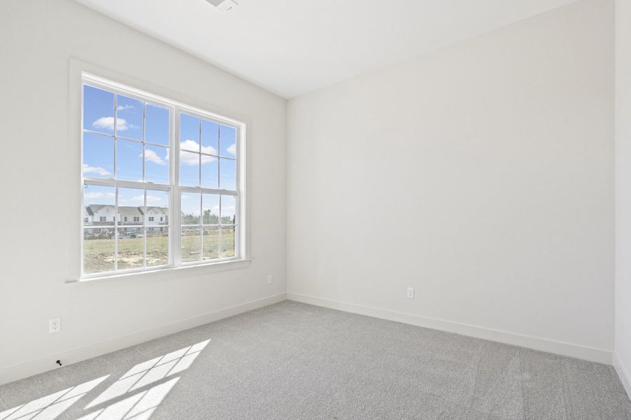 Empty room with light carpet and baseboards