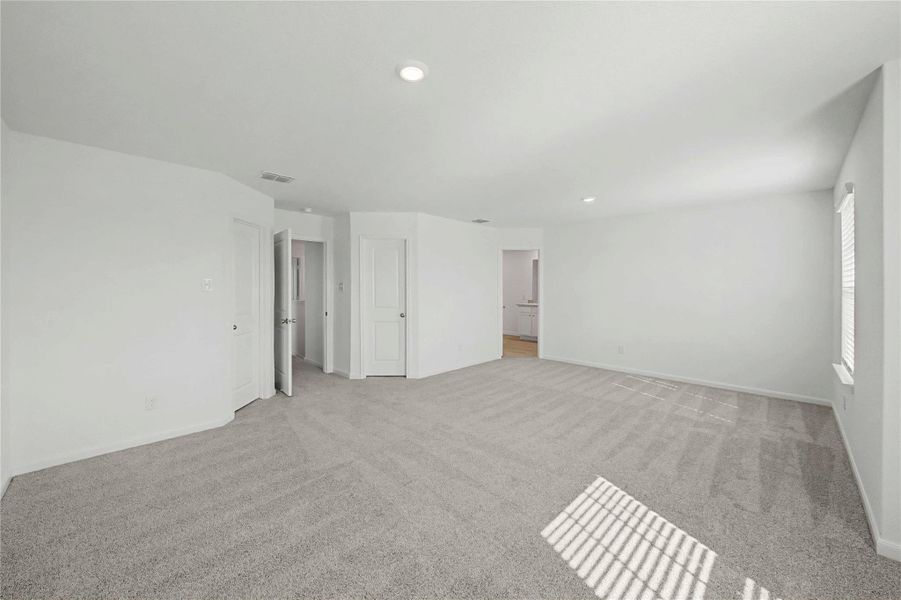 Unfurnished bedroom with light colored carpet and recessed lighting