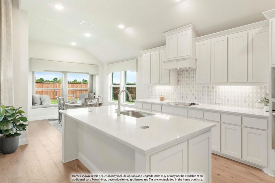 Kitchen with white cabinets, center island with sink, tile backsplash, and light wood floors open to dining area.