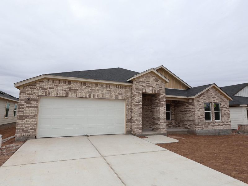 Front exterior of a new home in Carillon, Manor, TX, highlighting curb appeal (Image 9).
