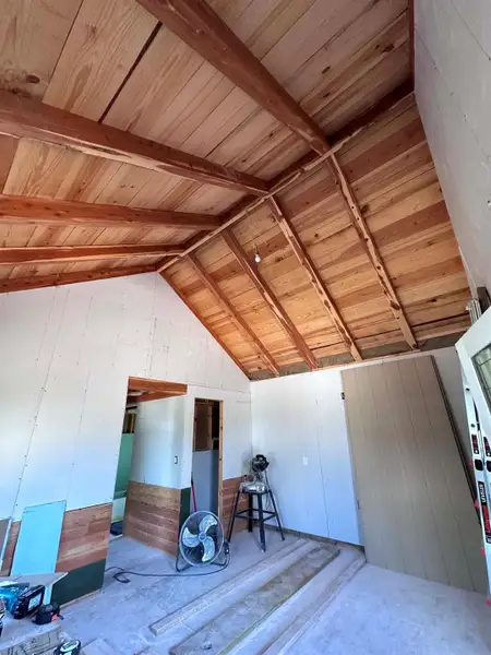 Exposed wood beams add rustic charm to this room under construction.