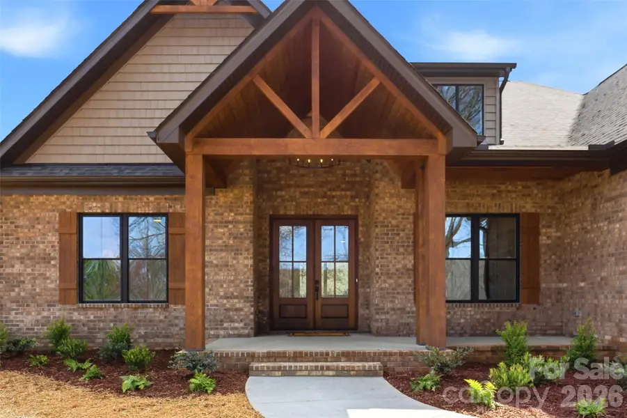 Vaulted covered front porch w/ wood ceiling & 10 ft Oak beams