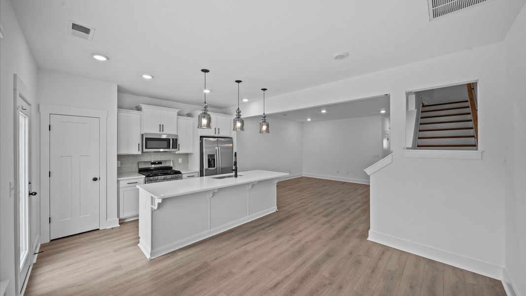 Tasteful design meets functional luxury in this kitchen with a 9-foot island and modern pendant lighting