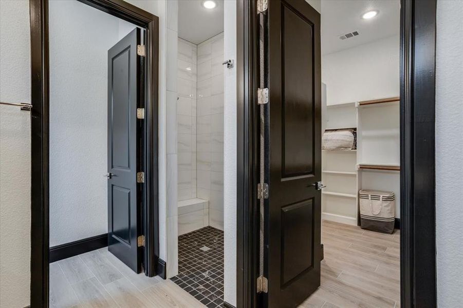 Bathroom with tile finish floors, a stall shower, and a walk in closet