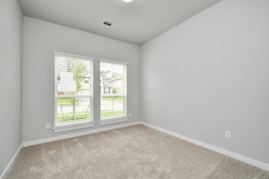 At the forefront, a refined guest suite.  Luxurious details like plush carpet, custom paint, expansive windows with privacy blinds.  Sample photo of completed home with similar floor plan. As-built interior colors and selections may vary.