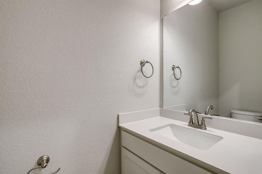 Bathroom with vanity and a textured wall