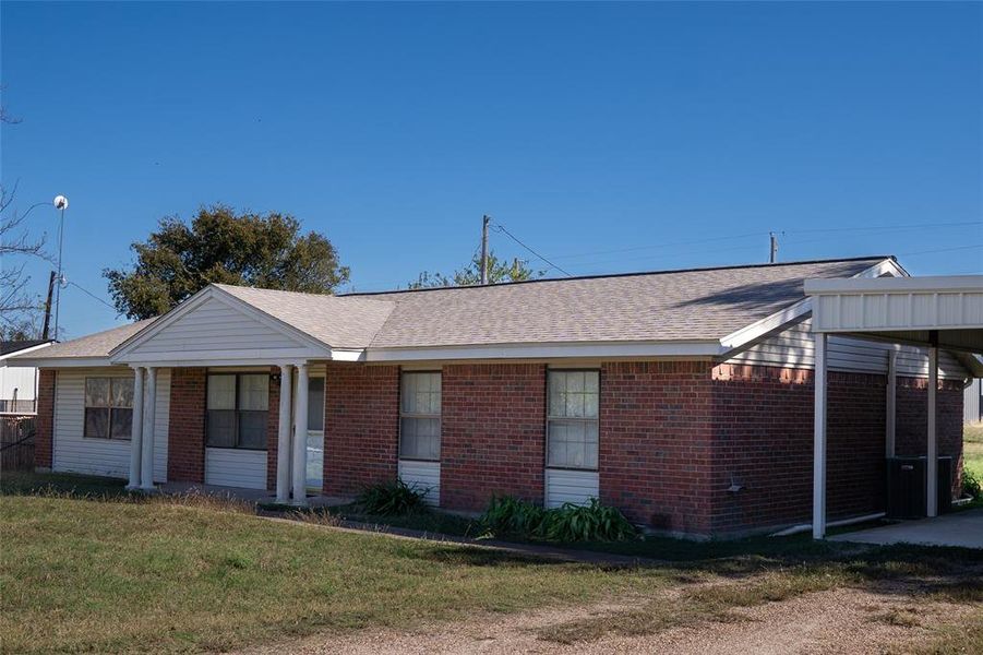 Ranch-style home featuring a front lawn, a shingled roof, and brick siding