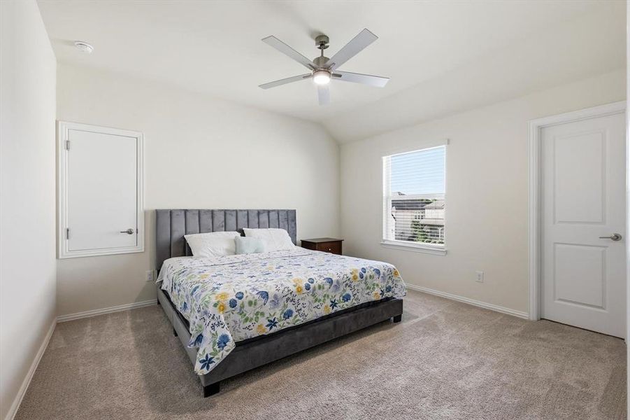 Carpeted room featuring a ceiling fan, a window with horizontal blinds, and a paneled interior door