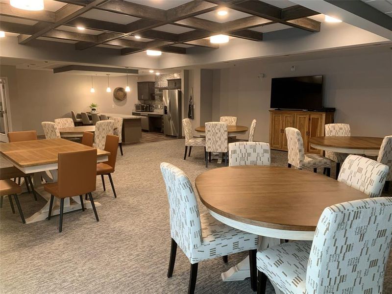 Dining space featuring light carpet, coffered ceiling, and beam ceiling
