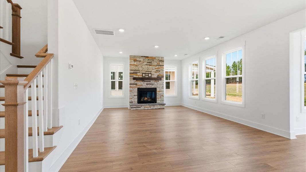 Spacious family room with rich hardwood flooring and elegant trim work in a reputable DRB Homes build at Foxbank