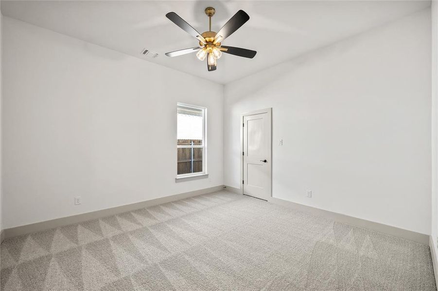 Carpeted empty room with baseboards and ceiling fan