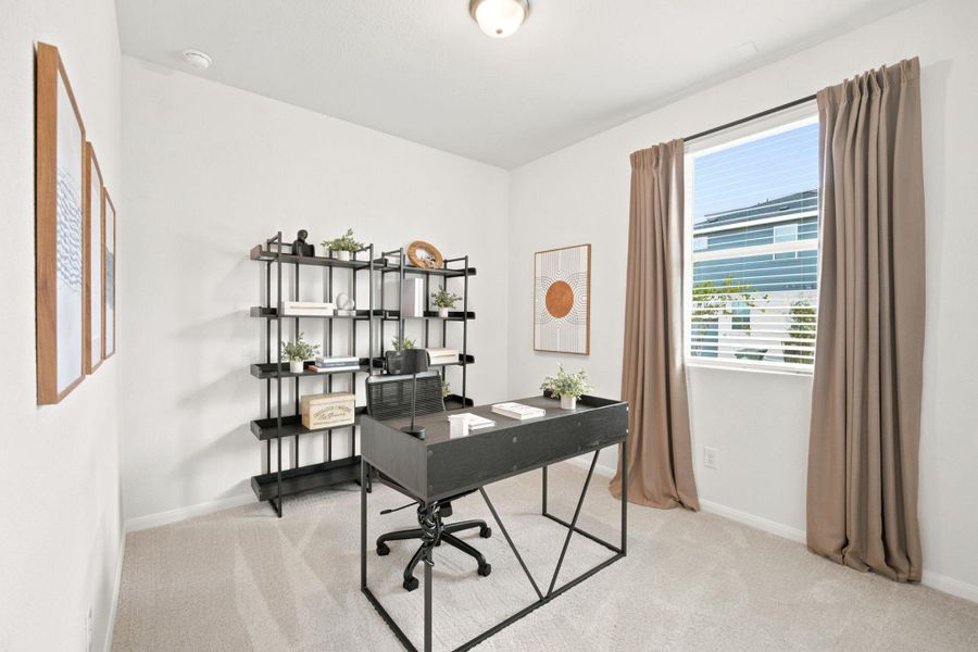 Plentiful natural light fills a versatile workspace lined with plush neutral carpeting.