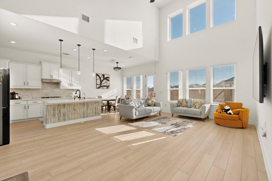 Living room with light wood-type flooring, ceiling fan, and recessed lighting