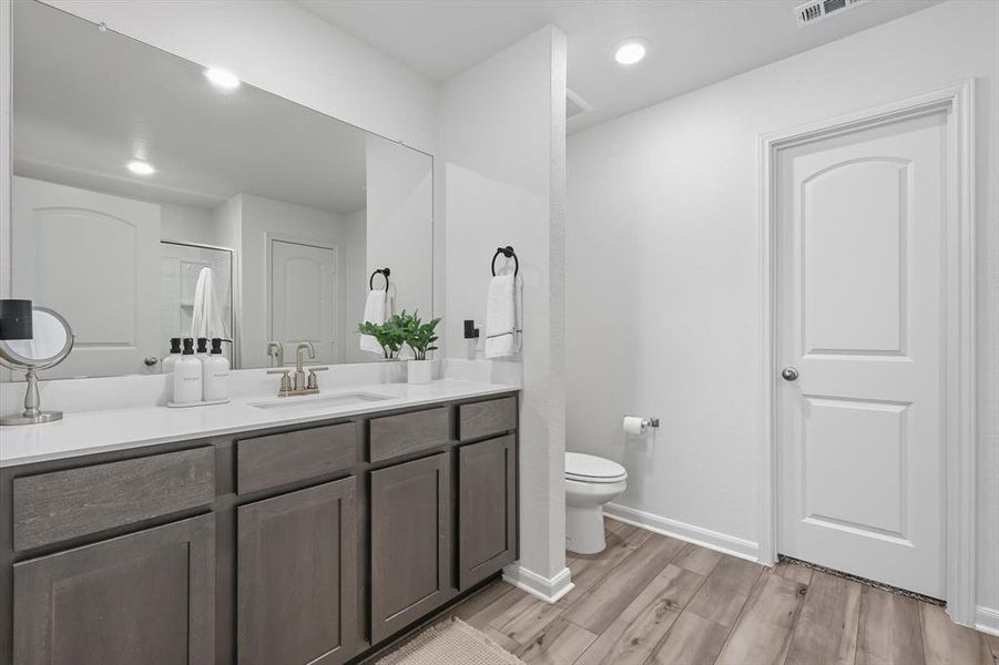 Bathroom featuring vanity, light wood-style floors, a shower with door, and recessed lighting