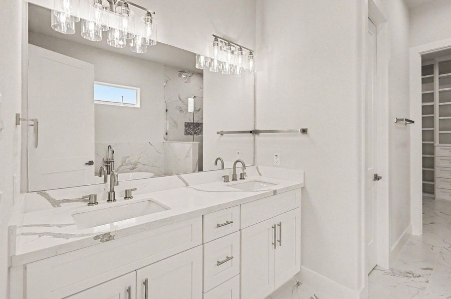 Elegant dual-sink vanity with quartz counters, modern fixtures, and designer lighting.