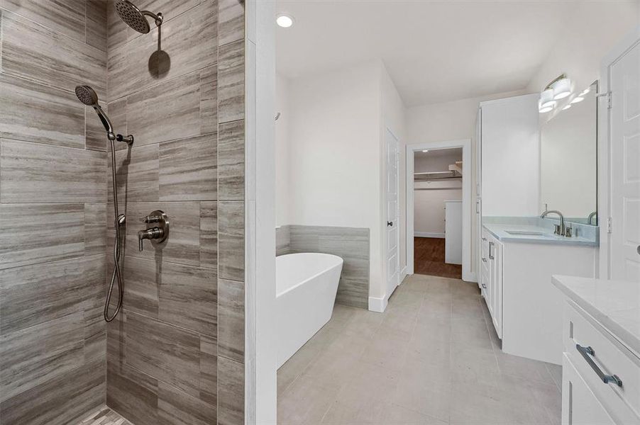 Bathroom featuring tile patterned floors, separate shower and tub, and vanity