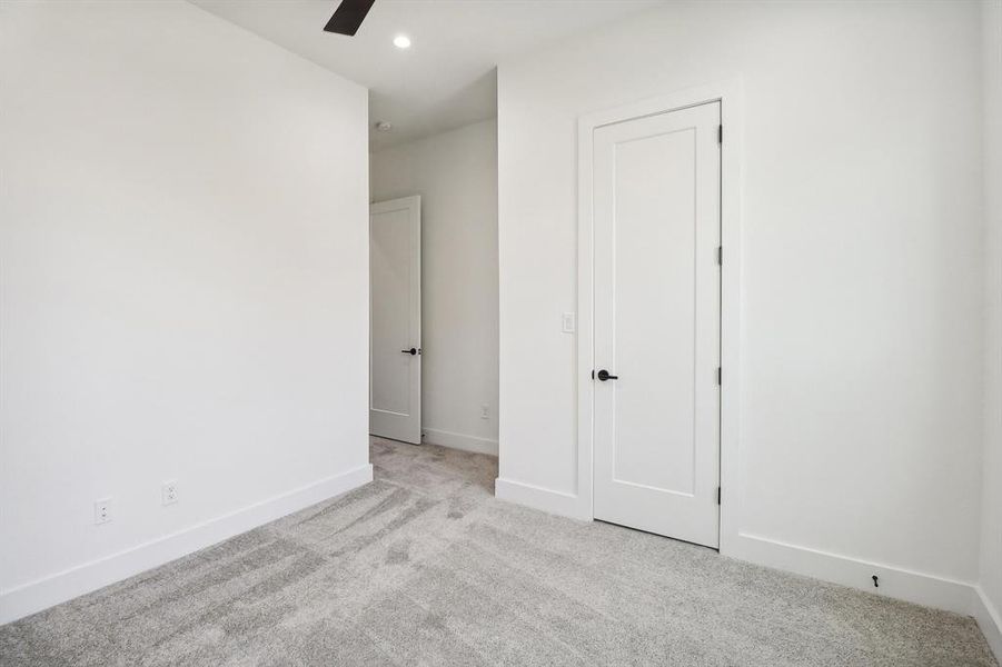 Unfurnished bedroom featuring light carpet and ceiling fan