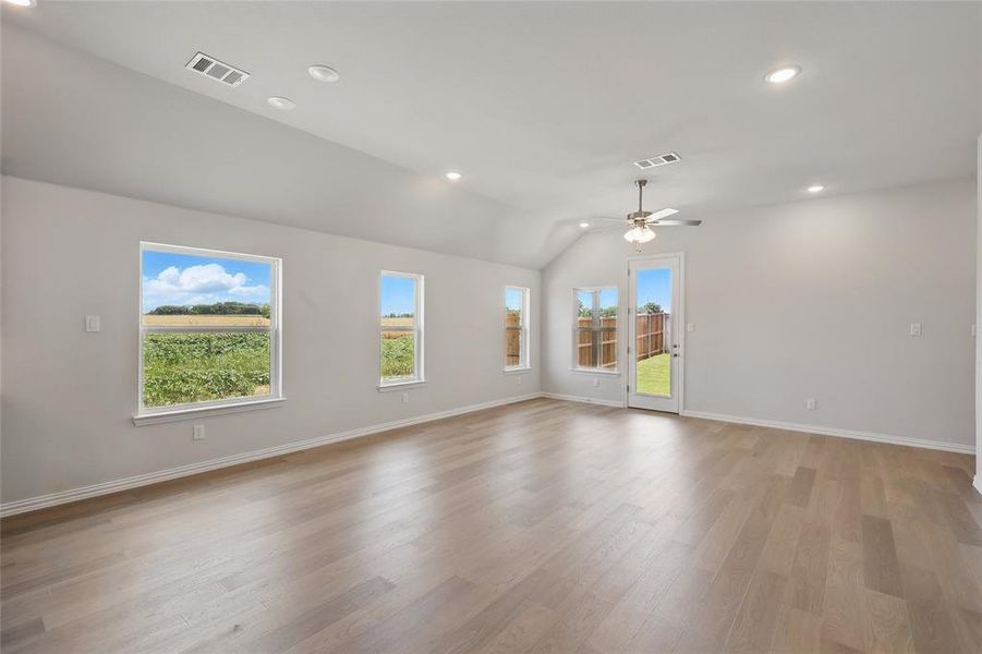 Empty room with a ceiling fan, lofted ceiling, light wood finished floors, recessed lighting, and baseboards