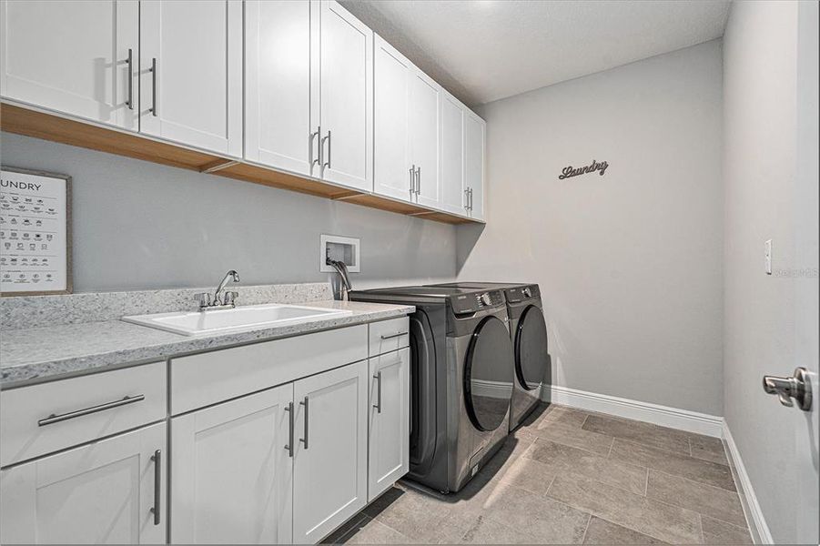 Laundry room! Tons of cabinet spaces & sink. Second floor