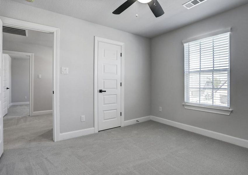 Secondary bedroom with carpet, a window and a walk-in closet.