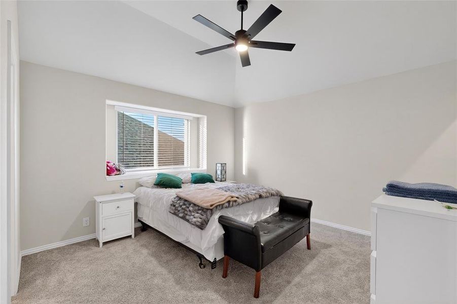 Bedroom with light carpet, lofted ceiling, and ceiling fan Bedroom with light carpet, lofted ceiling, and ceiling fan