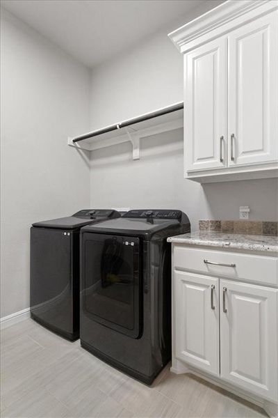 Laundry area featuring cabinet space, baseboards, and independent washer and dryer