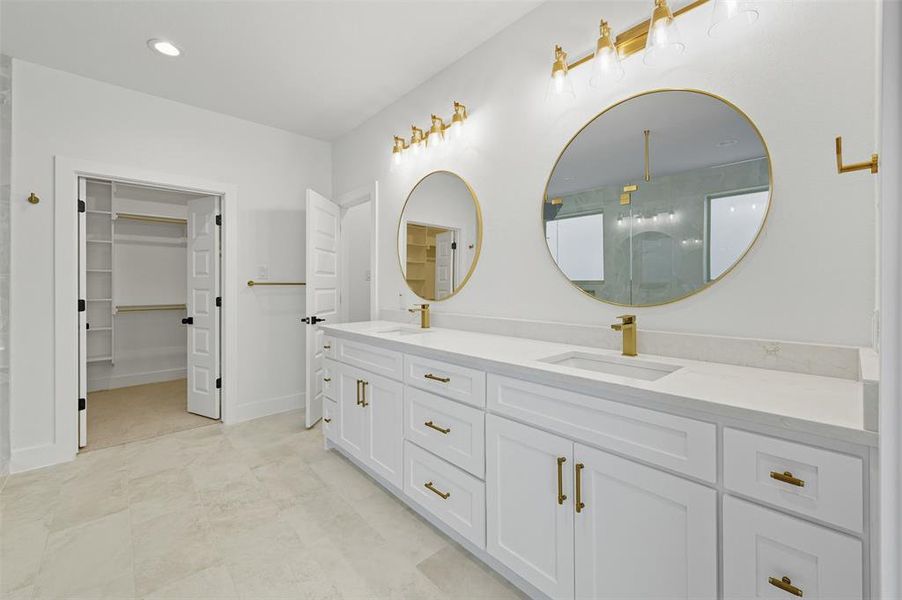 Bathroom featuring double vanity, a stall shower, a walk in closet, and recessed lighting