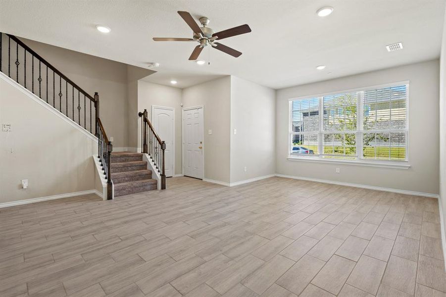 Unfurnished living room featuring stairs, recessed lighting, light wood finished floors, and ceiling fan Unfurnished living room featuring stairs, recessed lighting, light wood finished floors, and ceiling fan