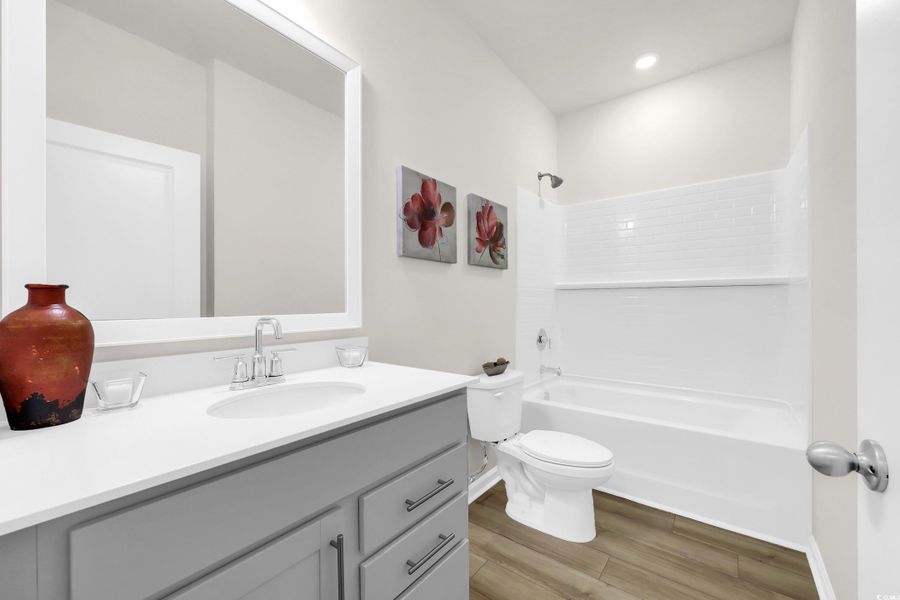 Bathroom featuring vanity, light wood-type flooring, and shower / washtub combination