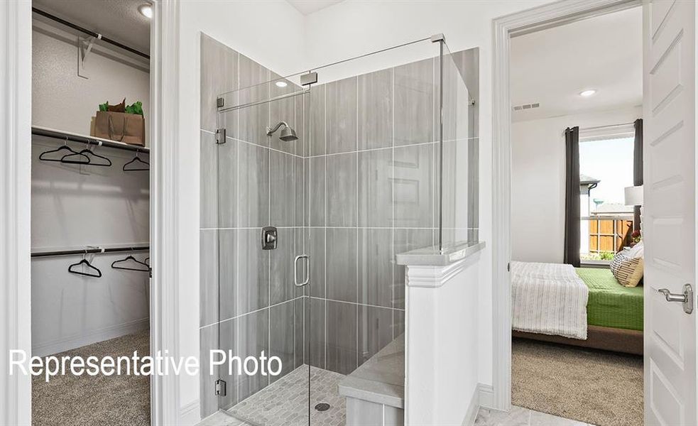 Glass-enclosed shower with gray tiled walls and a built-in bench Glass-enclosed shower with gray tiled walls and a built-in bench
