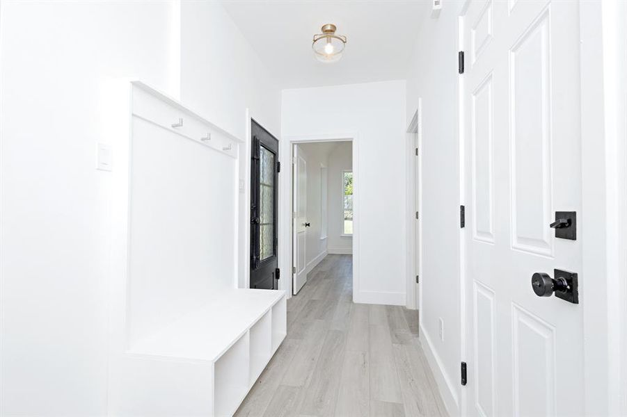 Mudroom featuring light wood-style floors and baseboards