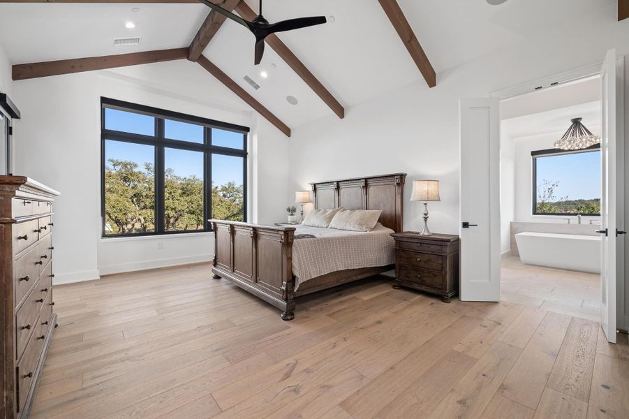 Bedroom featuring visible vents, multiple windows, and light wood finished floors Bedroom featuring visible vents, multiple windows, and light wood finished floors