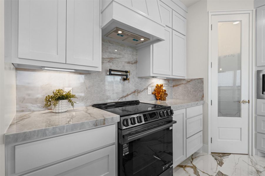 Elegant stone countertops and custom cabinetry elevate this modern cooking space.