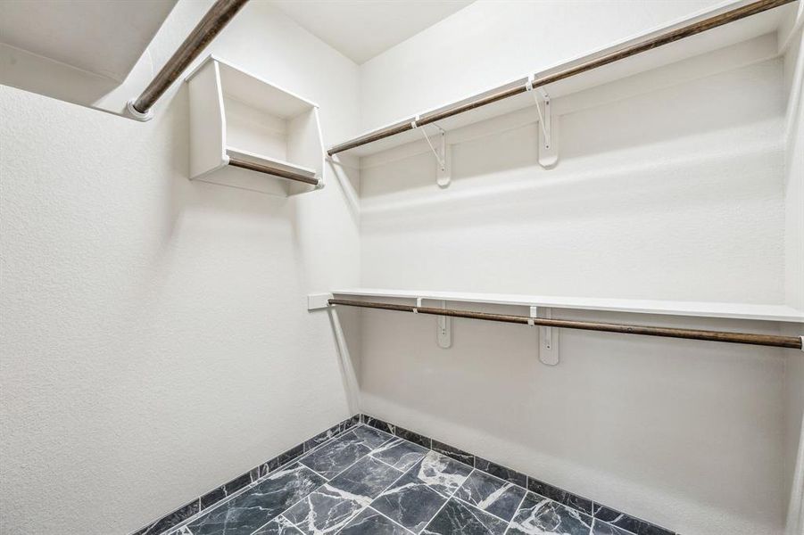 Spacious closet featuring marble finish floor