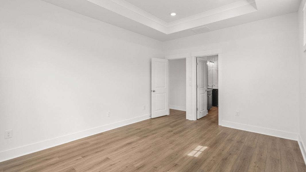 Primary suite with tray ceiling and private entry to the luxurious bathroom. Primary suite with tray ceiling and private entry to the luxurious bathroom.