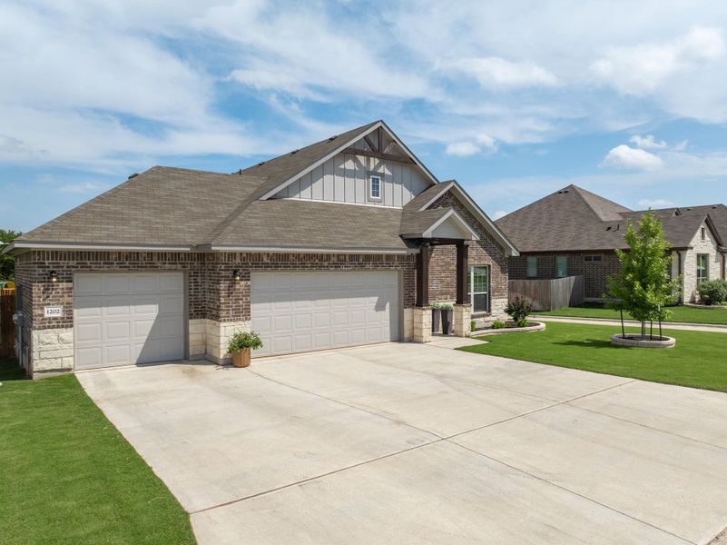 A well-kept lawn and a spacious concrete driveway lead to a charming brick-and-siding residence. A well-kept lawn and a spacious concrete driveway lead to a charming brick-and-siding residence.