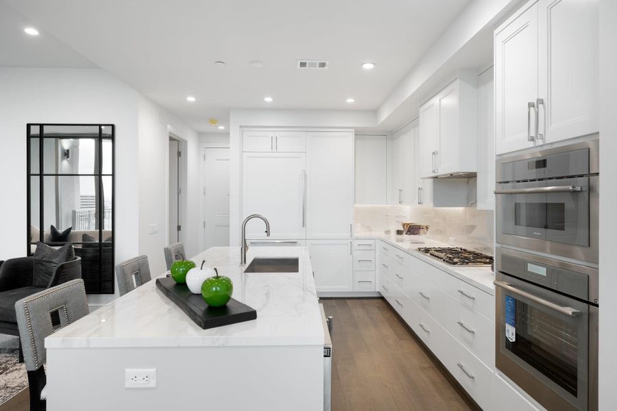 A large island with waterfall edges offers ample prep space and casual seating. A large island with waterfall edges offers ample prep space and casual seating.