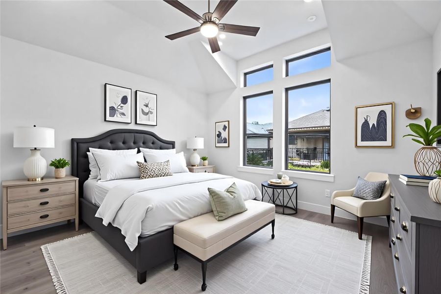 Relax and unwind after a long day in this impressive primary suite! This generously sized room offers laminate flooring, neutral-toned paint, high sloped ceilings with a ceiling fan, and large windows for added comfort and tranquility. *Virtually Staged