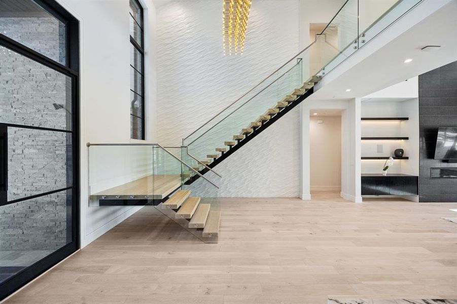 Stairs featuring hardwood / wood-style flooring, a high ceiling, and a chandelier