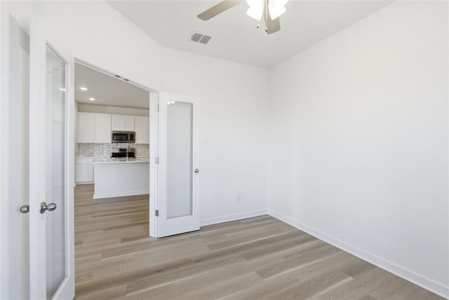 Spare room featuring light wood-type flooring, ceiling fan, and recessed lighting