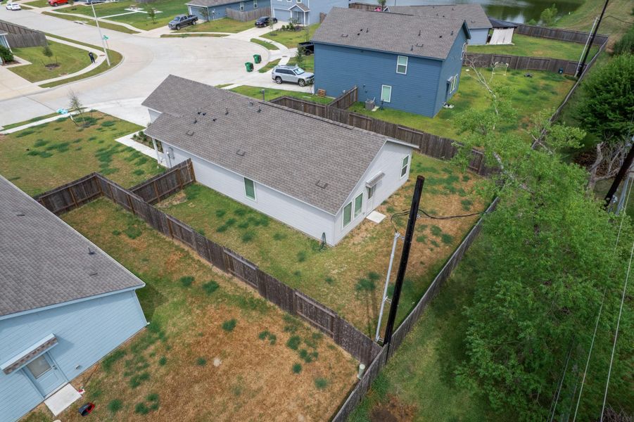 Elevated rear view showcases the home’s fenced backyard and surrounding outdoor space. Elevated rear view showcases the home’s fenced backyard and surrounding outdoor space.