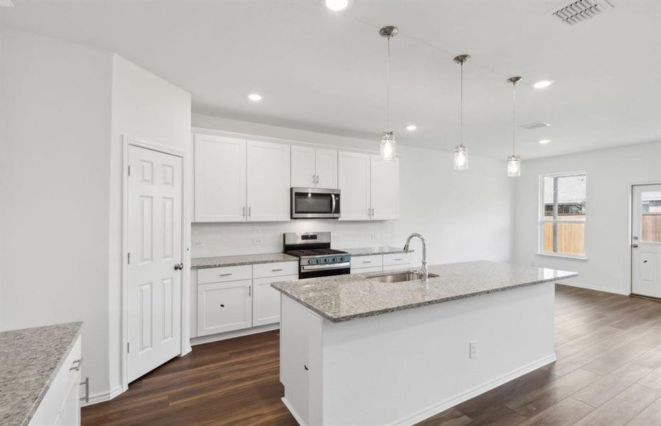 Spacious kitchen with oversized island *real home pictured