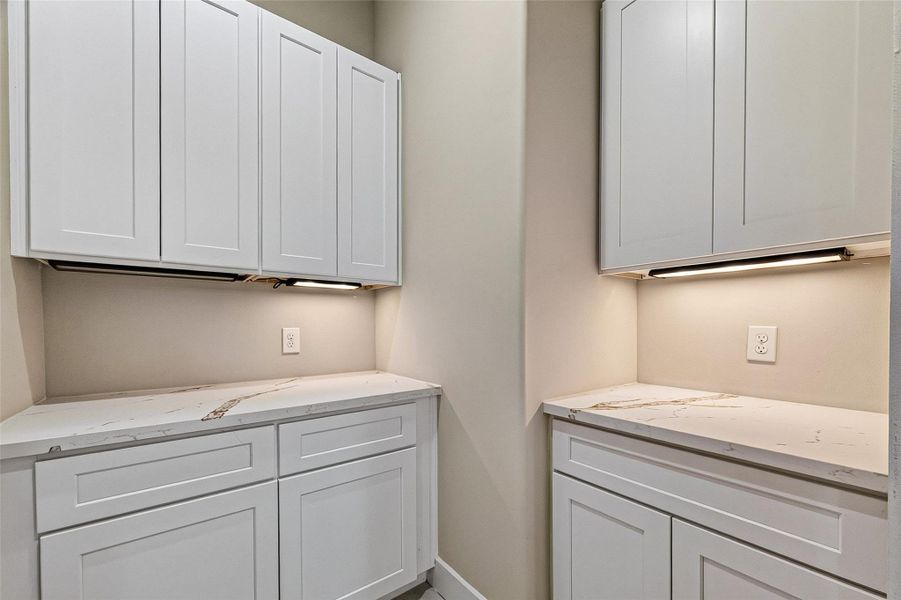 Spacious laundry room featuring extensive cabinetry for ample storage and organization. Spacious laundry room featuring extensive cabinetry for ample storage and organization.