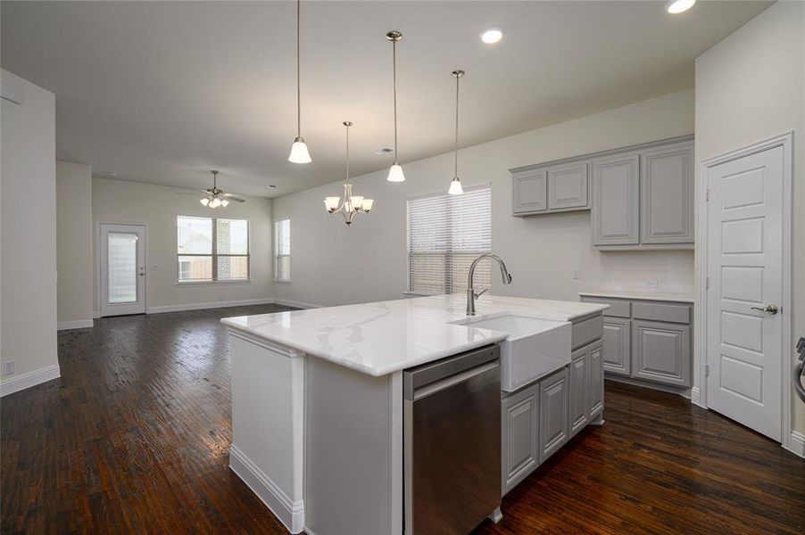Kitchen with gray cabinets, dishwasher, dark hardwood / wood-style floors, and a kitchen island with sink