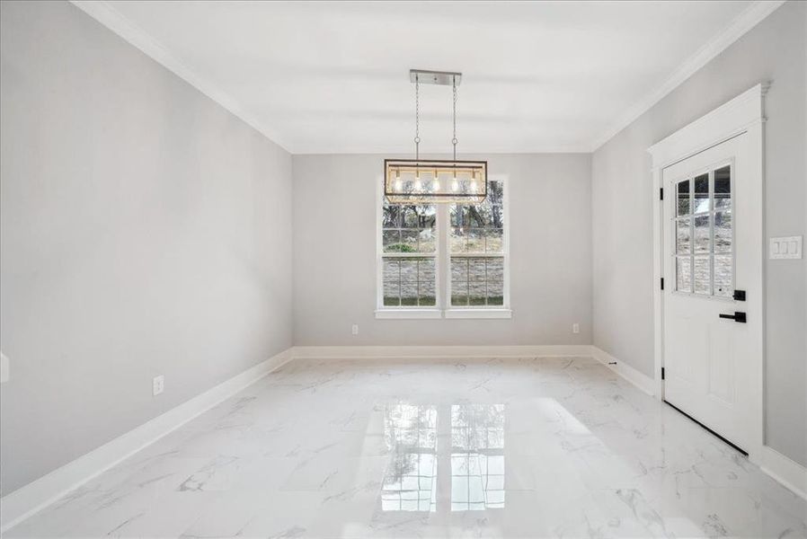 Unfurnished dining area featuring crown molding and a chandelier