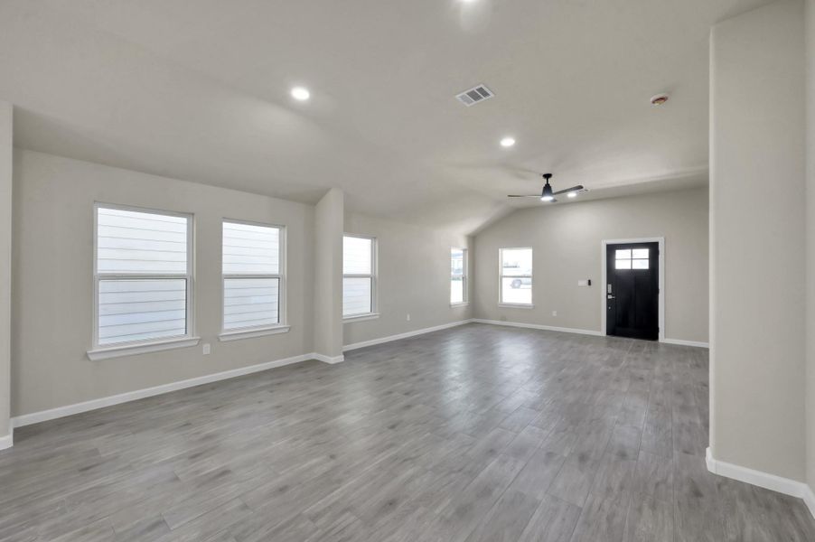 Looking back toward the entry, notice the designer ceiling fan and the abundant natural light pouring through the large energy-efficient windows.