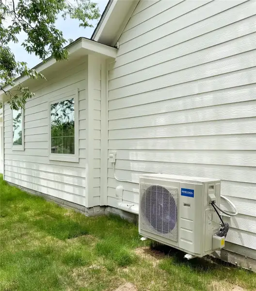 Exterior lap siding on the sides of the house featuring a Mr Cool quiet air conditioning unit, white trim, and multiple dual pane windows Exterior lap siding on the sides of the house featuring a Mr Cool quiet air conditioning unit, white trim, and multiple dual pane windows